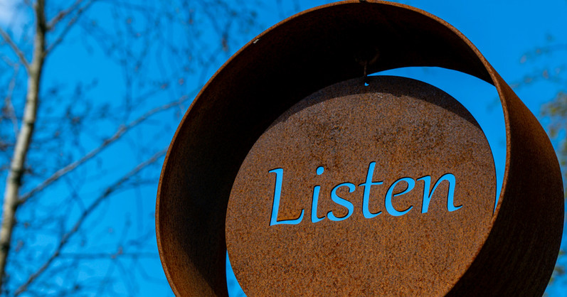 Round brown steel wheel with word listen carved into it