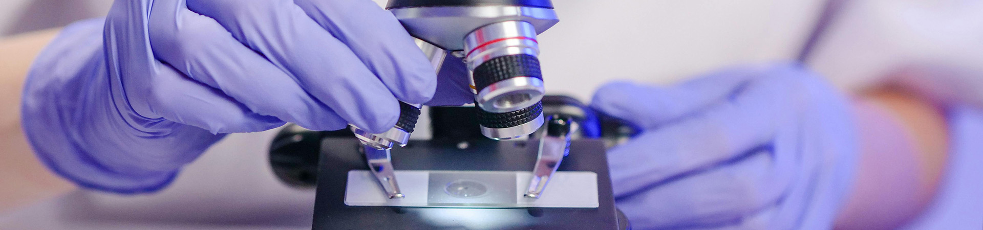 A scientist examining a sample through a microscope